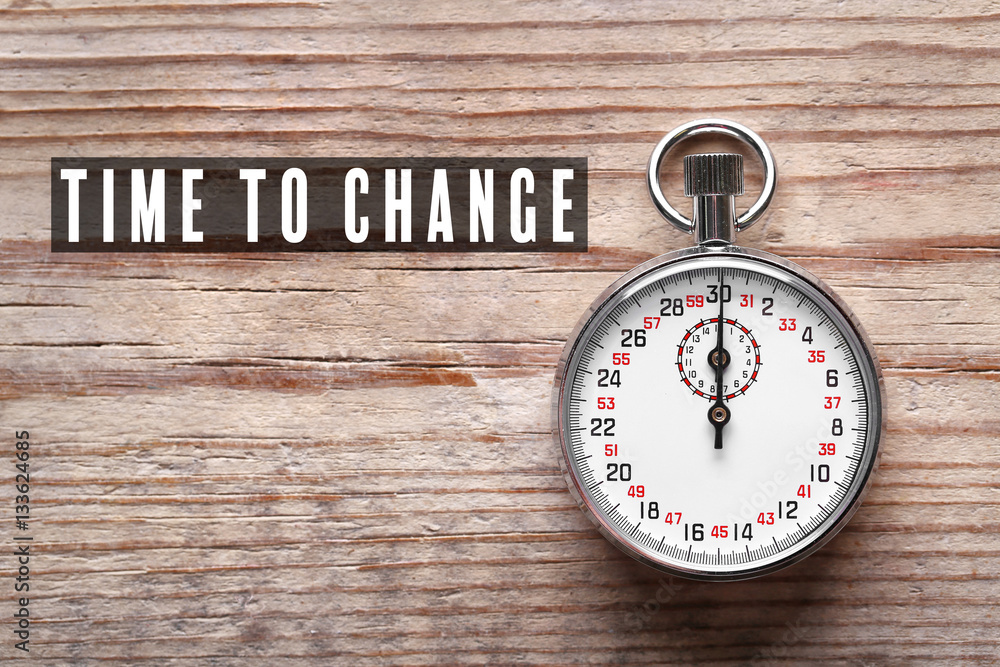 Stopwatch and text TIME TO CHANGE on wooden background Stopwatch and text TIME TO CHANGE on wooden background