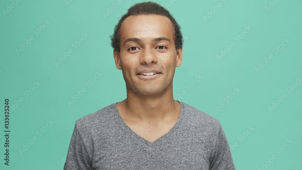 Smiling afro american man looking at camera isolated on the green background Smiling afro american man looking at camera isolated on the green background