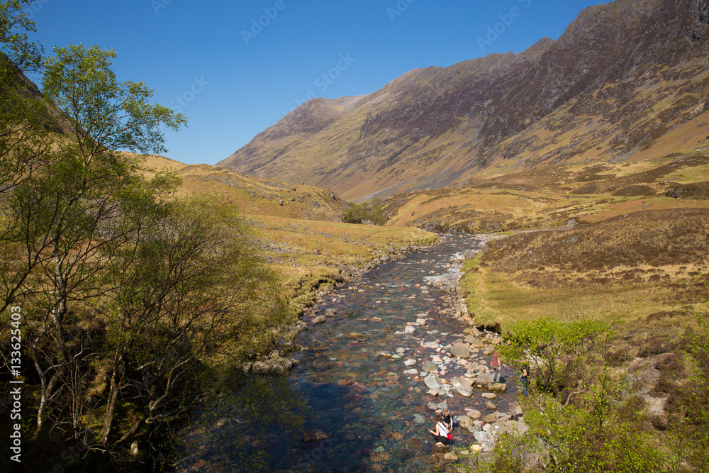 River Clachaig Glencoe Scotland UK Scottish country scene in Scottish Highlands in sunshine blue sky