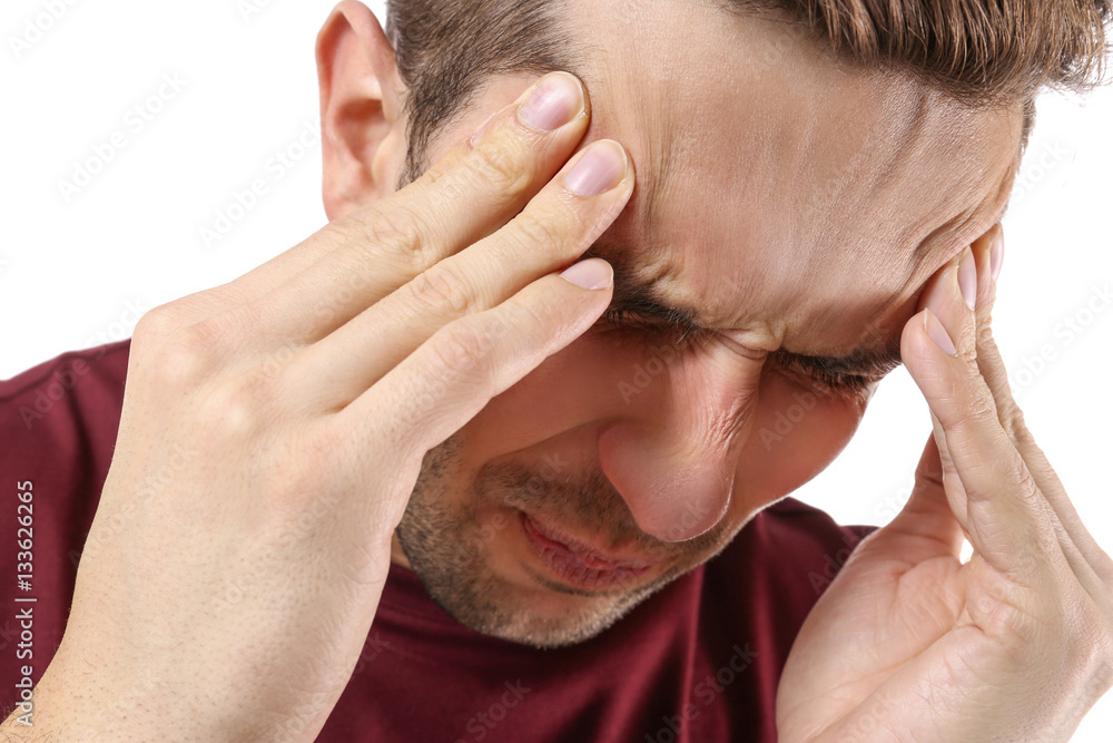 Fotografie Young man suffering from headache on white background, closeup