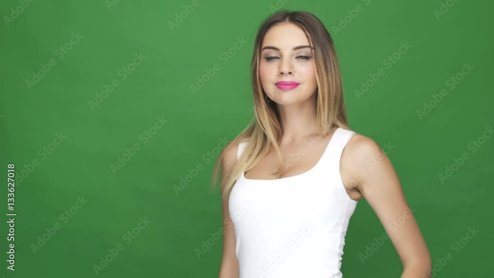 Attractive young woman looking at camera and smiling while standing isolated on white background Attractive young woman looking at camera and smiling while standing isolated on white background