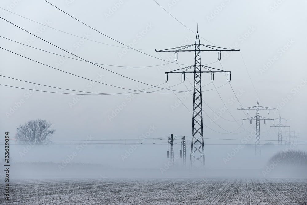 Landschaft mit einer Überlandleitung und Bodennebel Landschaft mit einer Überlandleitung und Bodennebel