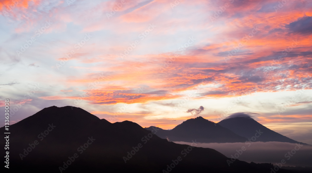 Sunrise in volcanic caldera of Batur Mountain with view to Batur, Agung and Abang volcanoes.