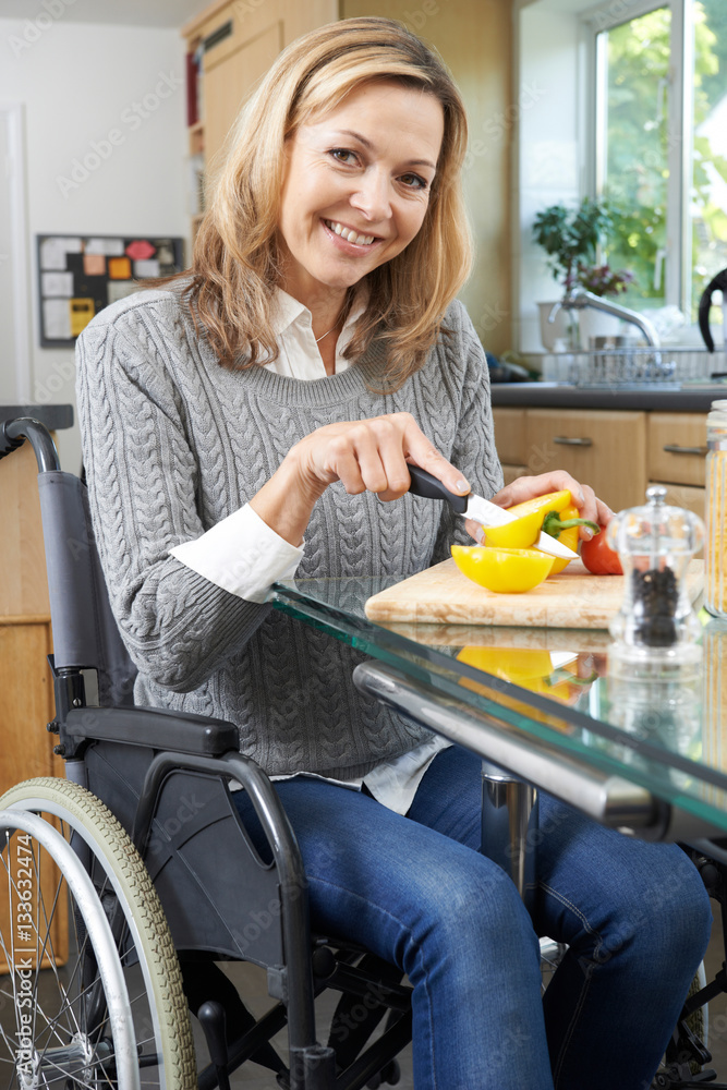 Woman In Wheelchair Chopping Vegetables In Kitchen StockFoto Adobe Stock