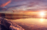  quadrocopter drone with remote control against colorfull sunset on river. close-up texture of waves on the river at sunset, colorful clouds on the sky over the morning river. majestic misty sunrise.