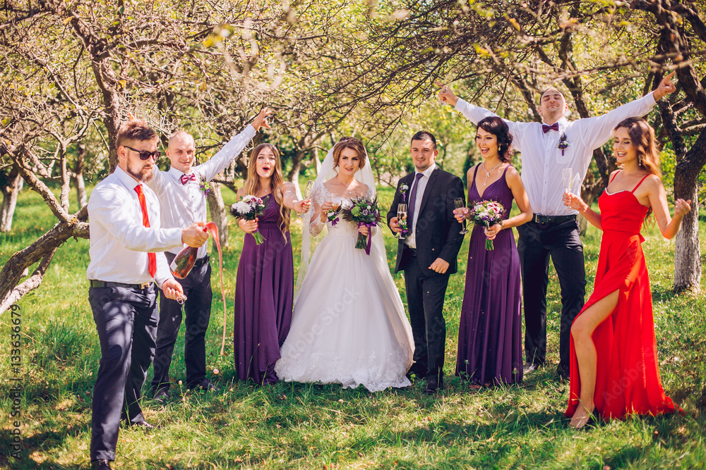 bride and groom with bridesmaids and groomsman having fun anf jump outdoor green park forest