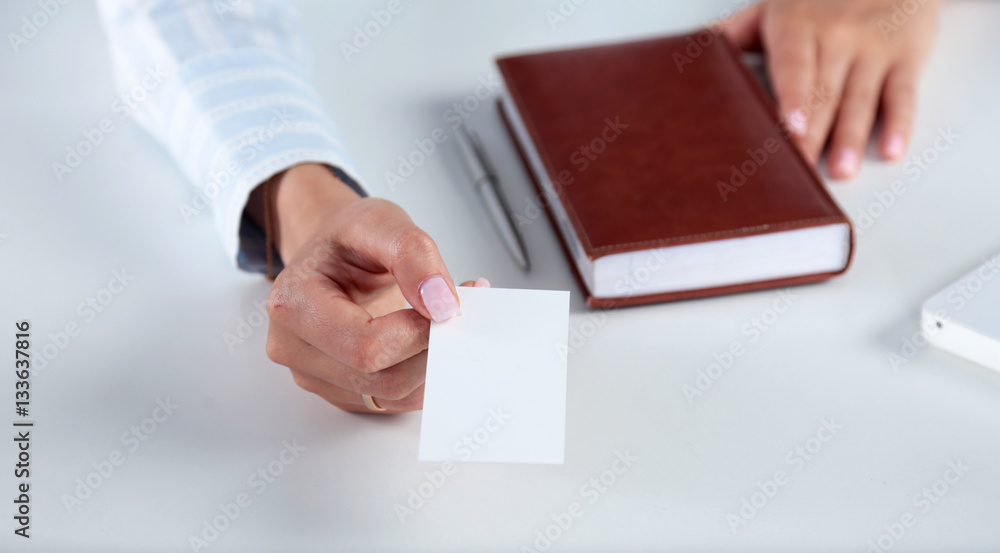Businesswoman holding blank visit card ,sitting on the desk Businesswoman holding blank visit card ,sitting on the desk