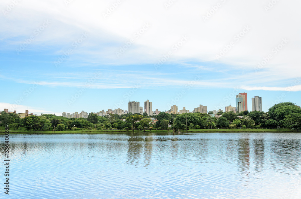 Lake reflecting on the water the city and the blue sky. Margins of the lake Igapo in Londrina, PR, Brazil.