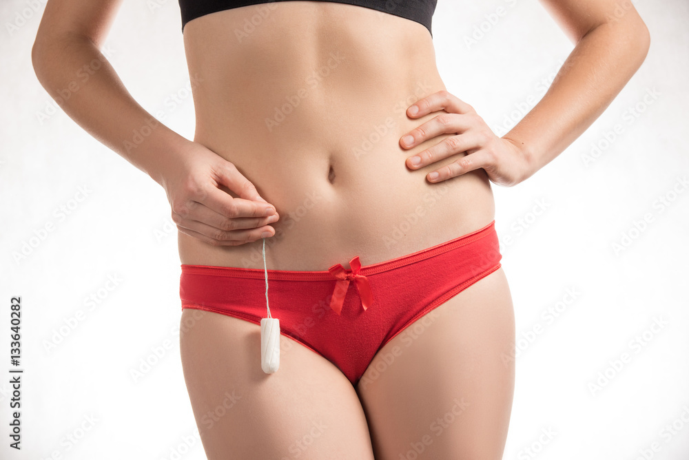 Girl in red shorts holding a hygienic tampons and pads during me Girl in red shorts holding a hygienic tampons and pads during me