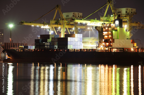 Large Container Ship is loading in a port at night.