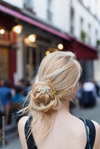 Blond girl with beautiful hair standing on a street of Paris, near the cafe