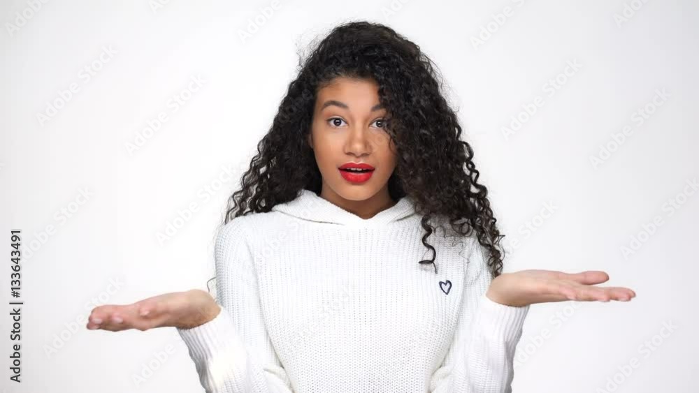 Surprised African woman in white sweater posing in studio and showing surprised gestures Surprised African woman in white sweater posing in studio and showing surprised gestures
