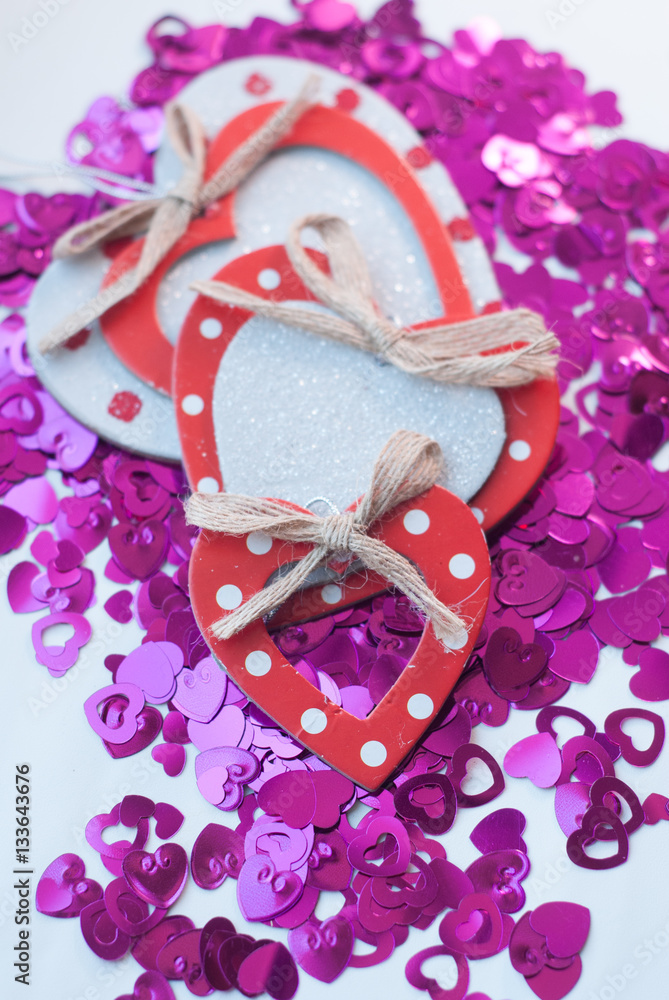Confetti in the shape of hearts scattered on the table. Confetti in the shape of hearts scattered on the table.