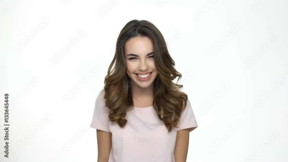 Excited young woman jumping out and waving her hand to a friend isolated