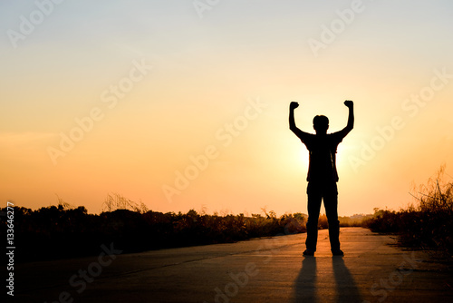 man standing on road at sunset background, silhouette