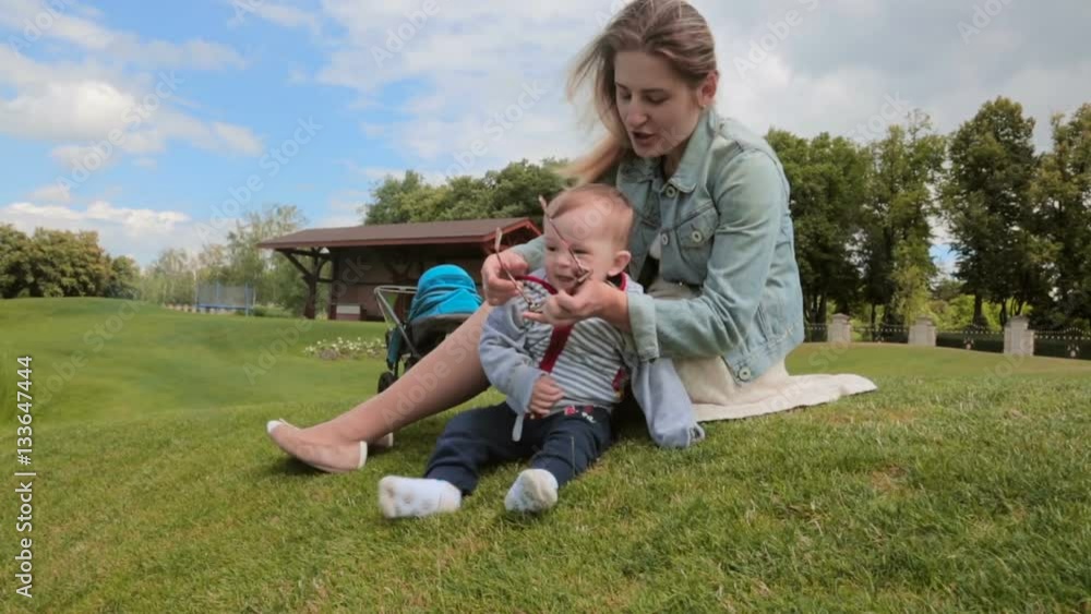 Happy smiling baby boy having fun with mother at park Happy smiling baby boy having fun with mother at park
