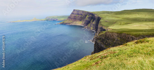 Misty Sea cliffs of Ramasaig with Neist Point in the distance. Isle of Skye, Scotland, UK.       photo