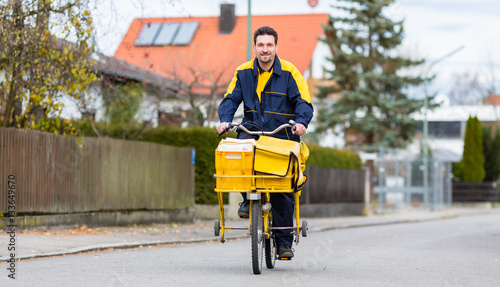 Canvastavla Briefträger fährt auf seinem Lastenfahrrad Post in Wohngebiet aus
