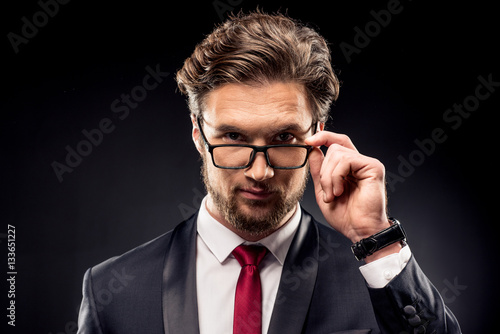 Businessman adjusting eyeglasses