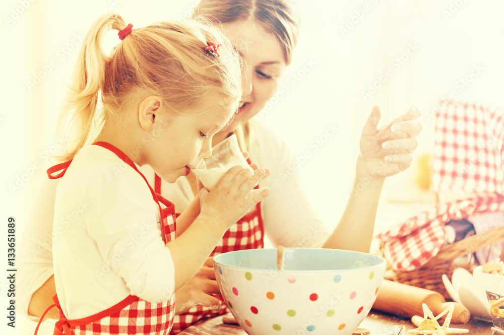 Family Time. Little Girl is drinking milk and preparing cakes wi Family Time. Little Girl is drinking milk and preparing cakes wi
