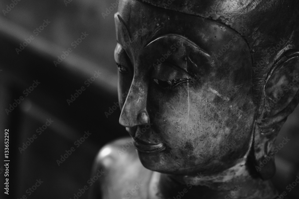 close up face on buddha head statue and black and white image style. Selective focus face buddha statue.