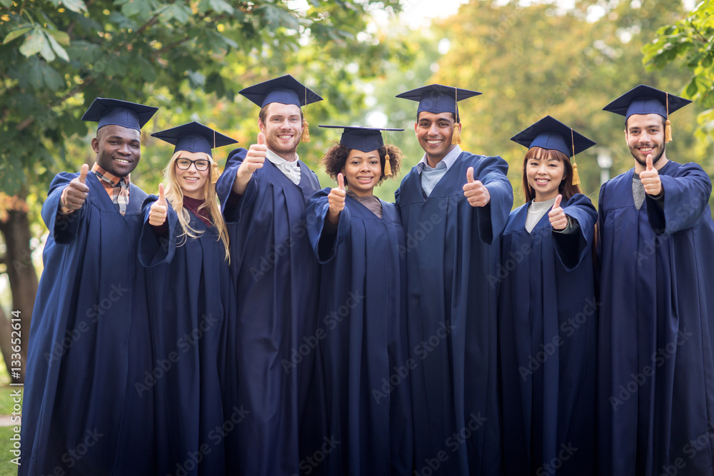 happy students or bachelors showing thumbs up