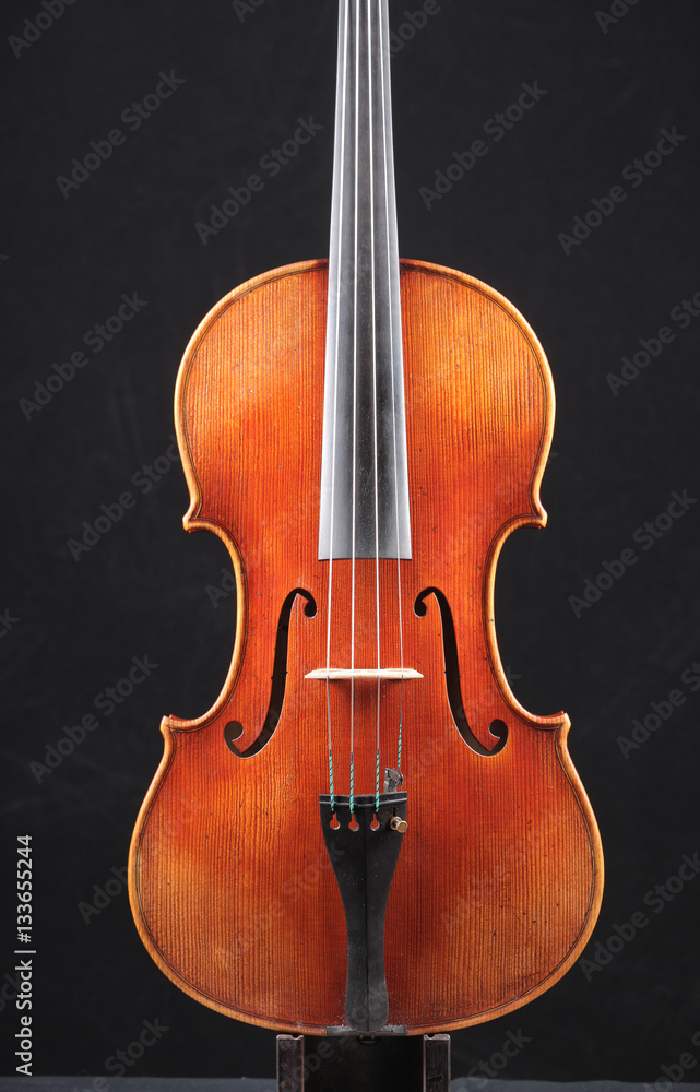 Old wooden violin on black background