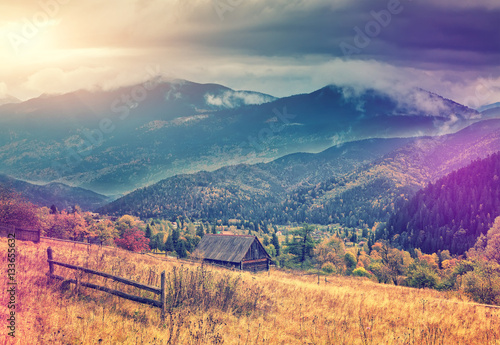 morning in the mountain village. wonderful rural landscape at sunrise. majestic mountains with overcast clouds. retro and vintage style. artistic creative image. instagram filter