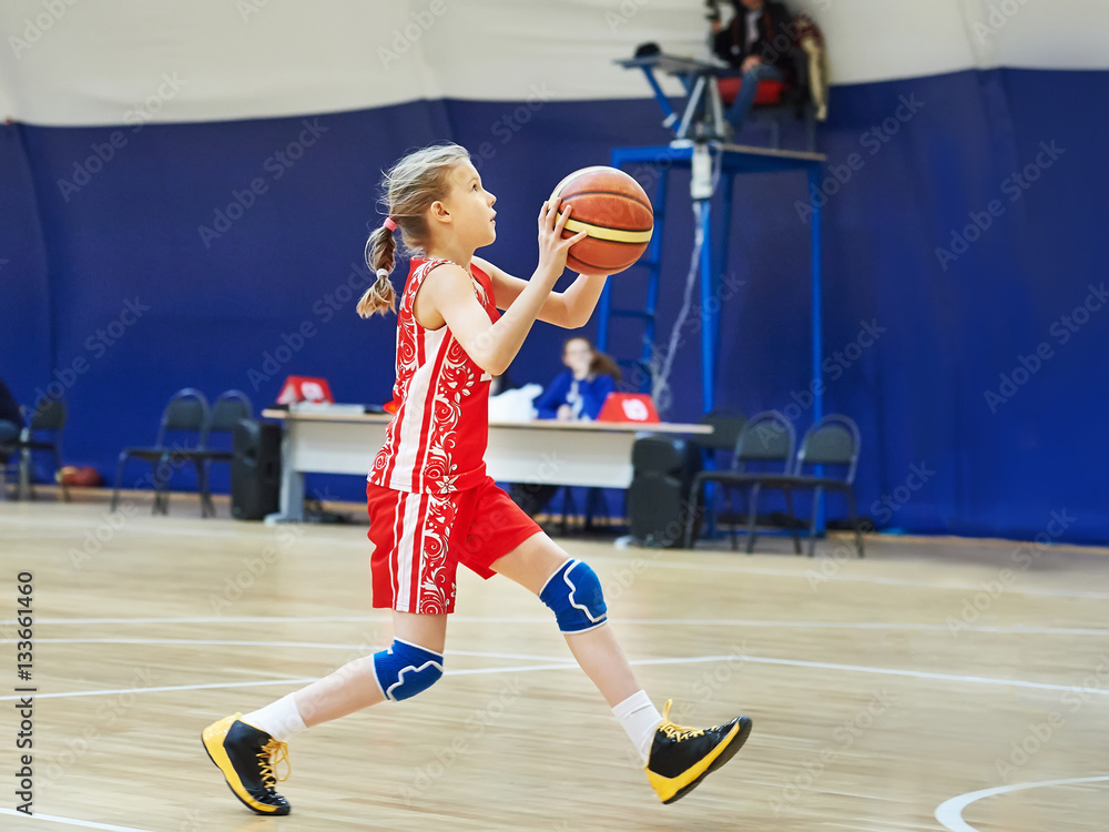 Girl athlete in uniform playing basketball
