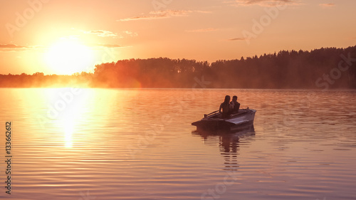 Romantic golden sunset river lake fog loving couple small rowing boat Romantic date beautiful Lovers ride boat during beautiful sunset Happy couple woman man together relaxing water nature around
