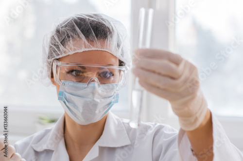 Young female scientist making experiments in laboratory