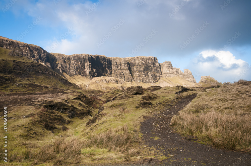 Obraz premium Sunshine over the Quiraing on the Inner Hebride Island of Isle of Skye with the footpath up to it in the foreground.