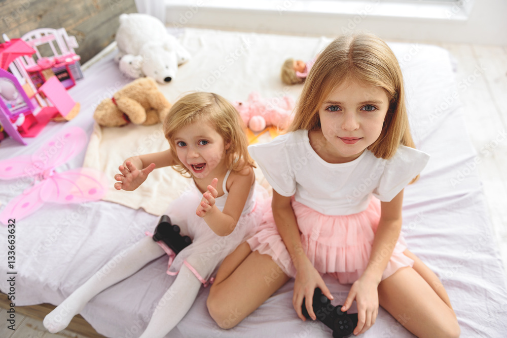 Carefree two sister having fun with videogame Carefree two sister having fun with videogame