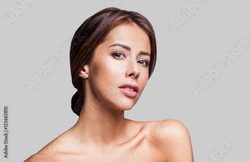 Studio portrait of a beautiful young woman with brunette hair. Pretty spa model girl with perfect fresh clean skin. Youth and skin care concept
