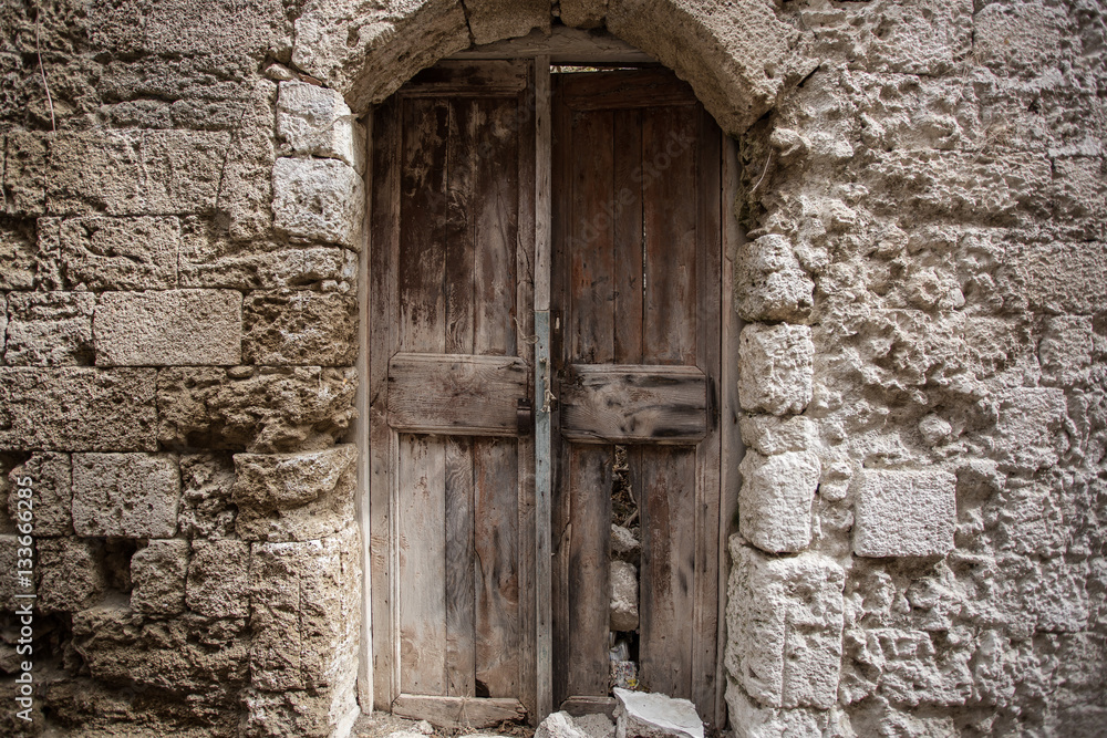 Old wooden door in the wall. Greece, Rhodes