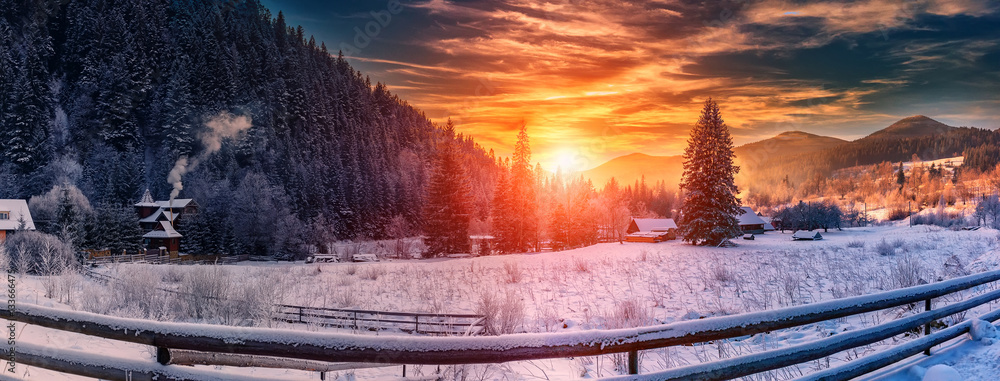 Fototapeta premium majestic sunset at winter. wonderful wintry view in mountain village. colorful sky over the hills. picturesque amazing scene. christmas concept. instagram toning. creative image.