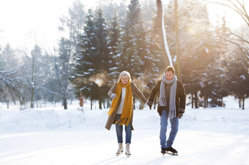 Senior couple in sunny winter nature ice skating.