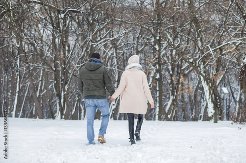 Happy loving couple walking in winter park enjoying snow © nikodash