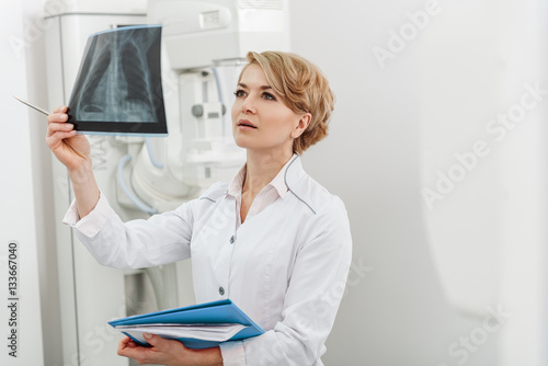 Interested female doctor holding radiograph © Yakobchuk Olena