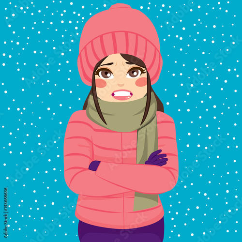 Woman shivering in cold winter outdoors wearing warm clothes on snowy day