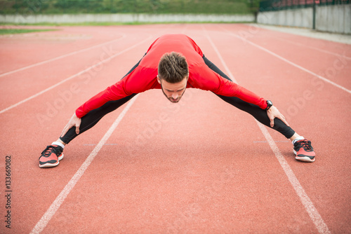 Athlete stretching on a track. Getting ready for a run.