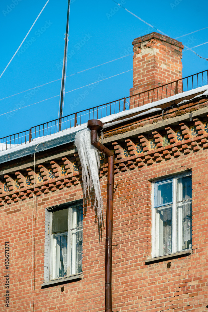 Icicle on the roof. Winter sunny day. Vivid splittoned image. Icicle on the roof. Winter sunny day. Vivid splittoned image.