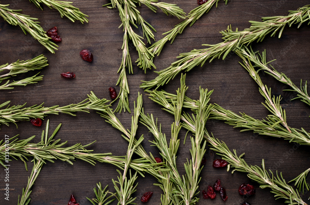 Obraz premium background rosemary, dried cranberries on a wooden table