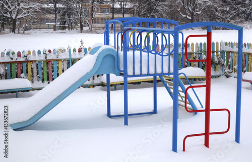 Children's playground covered with snow in winter photo