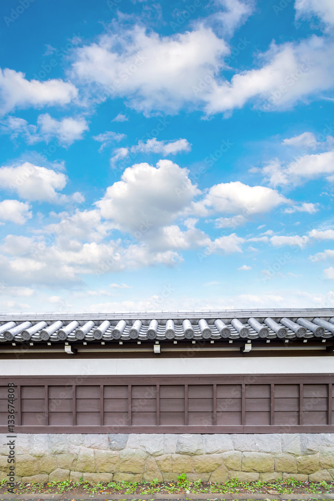 Ancient Traditional Japanese stone wall and old tiled roof from