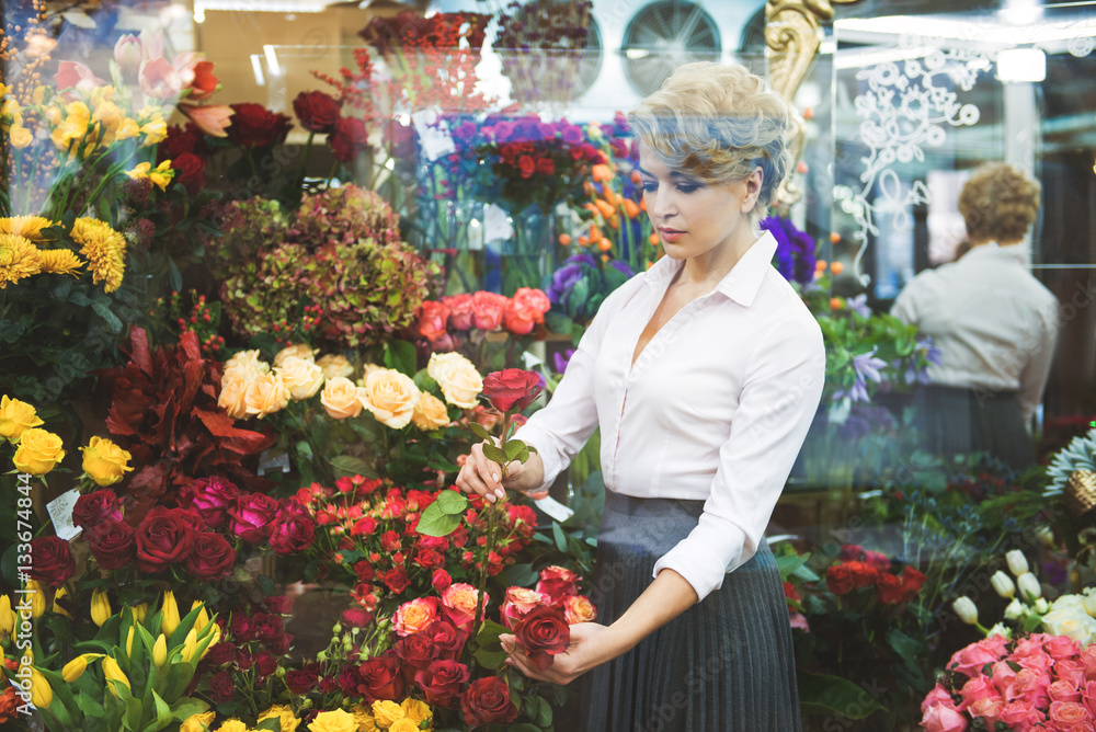 Calm woman making bouquet in shop