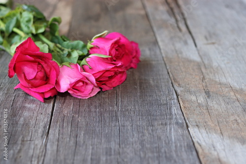 Selective focus and shallowf depth of field of bouquet of beautiful red roses on old wooden background. Valentine's Day concept