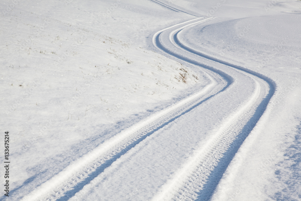 Car tire track on winter road