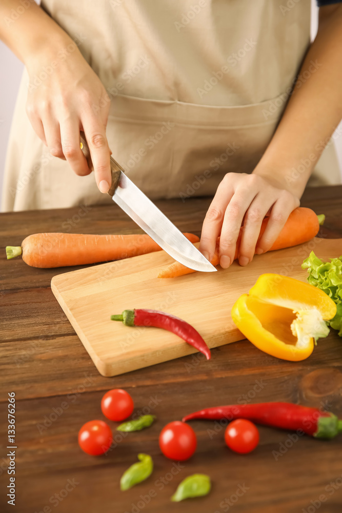 Woman chopping fresh vegetables on cutting board Woman chopping fresh vegetables on cutting board
