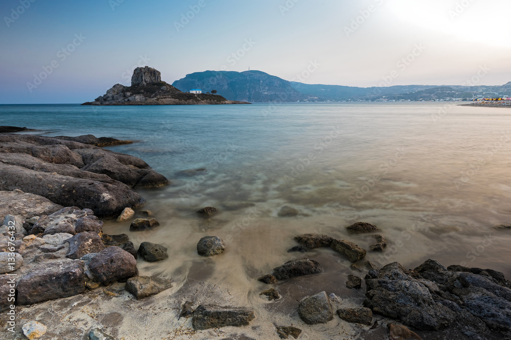 Landscape with rocky coastline and islet at sunset in Kos island, Greece